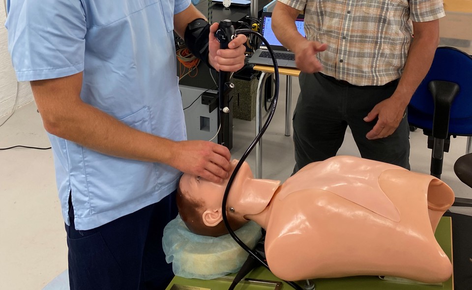 Man with tube inserted into training dummy
